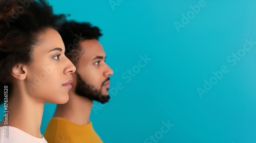 Side profile of a young man and woman against a blue background, capturing focus, determination, and a sense of purpose.