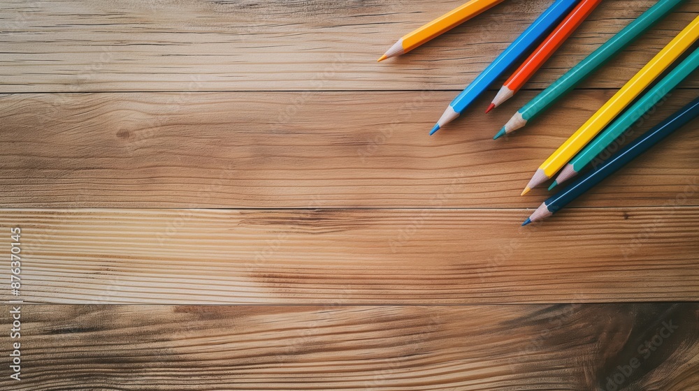 Top View of Wooden Table with Colorful Pencils for Art and Design Projects