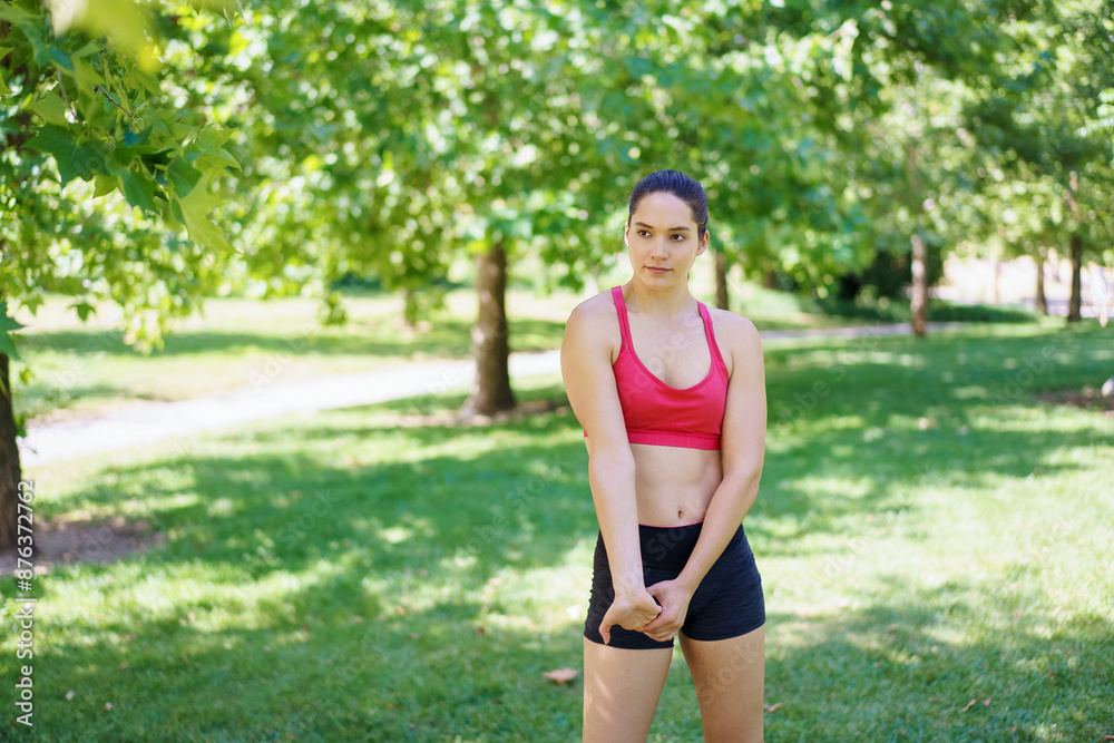 Young woman exercises outdoors in a park, showing determination and commitment to fitness under sunny skies Young woman exercises outdoors in a park, showing determination and commitment to fitness under sunny skies