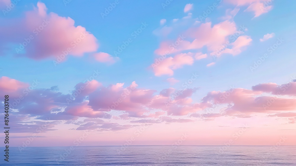 Obraz premium Cirrus clouds tinted pink by the sun at sunset over a calm blue ocean