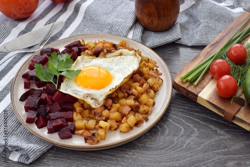 A traditional Scandinavian dish made from leftover chopped potatoes, onions and meat. Served with a fried egg and boiled beets. photo