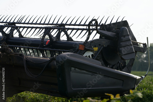 Close-up fragment of a cutterbar with a conveyor belt for windrowing in the field. Preparing fodder for livestock. photo