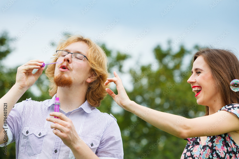 Obraz premium Couple blowing soap bubbles, having fun