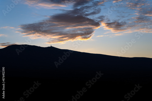 A VIEW OF MOUNT VENTOUX WITH A DARK FOREGROUND AND A CLEAR SKY WITH ONE MOODY CLOUD IN THE PROVENCE REGION OF FRANCE