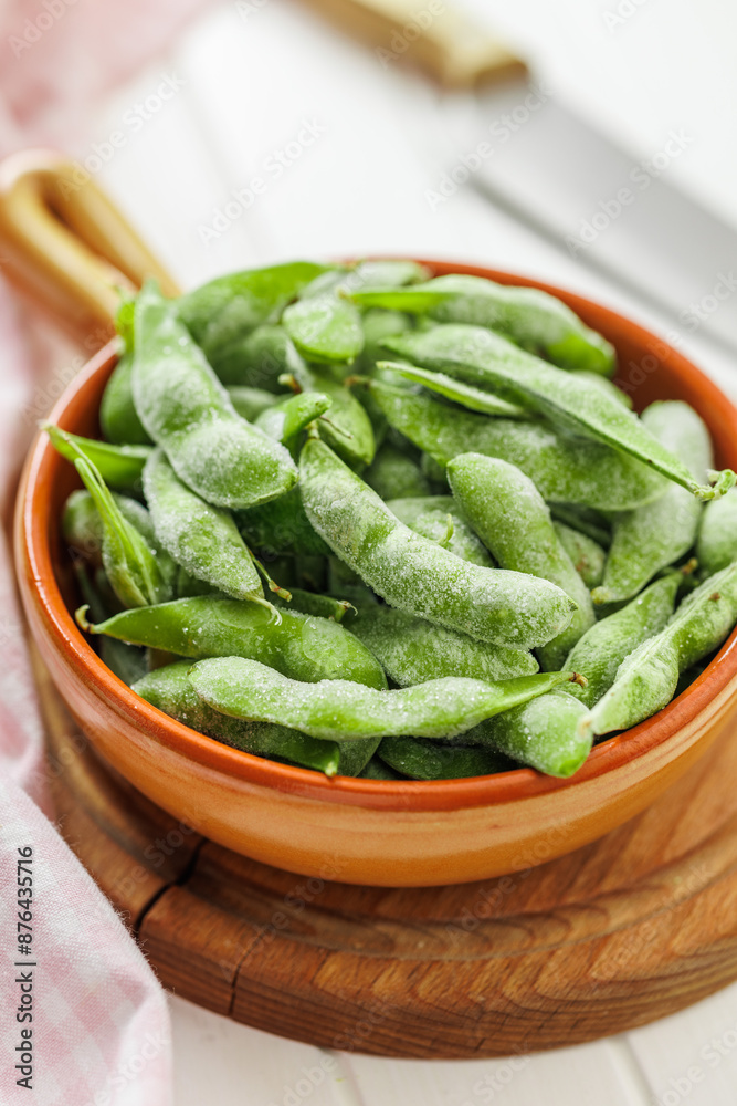 Green edamame pods. Fresh soybeans in bowl on cutting board. Green edamame pods. Fresh soybeans in bowl on cutting board.