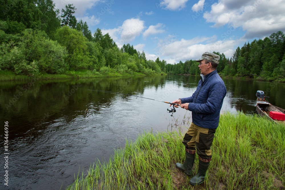 A man with a spinning is fishing on the river. A man with a spinning is fishing on the river.