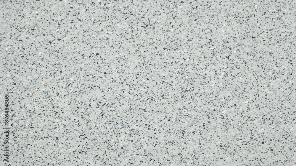 A white wall with a pattern of small dots. The wall is plain and unadorned. The dots are evenly spaced and cover the entire surface of the wall. The wall appears to be made of a smooth