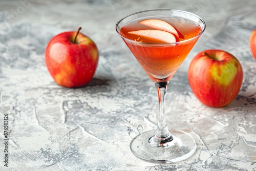 Close-Up of a Pink Cocktail With Apple Garnish on a White Stone Surface photo