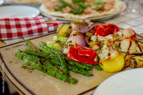 grilled vegetables on the grill. potatoes, mushrooms, green asparagus on a wooden board on the table.