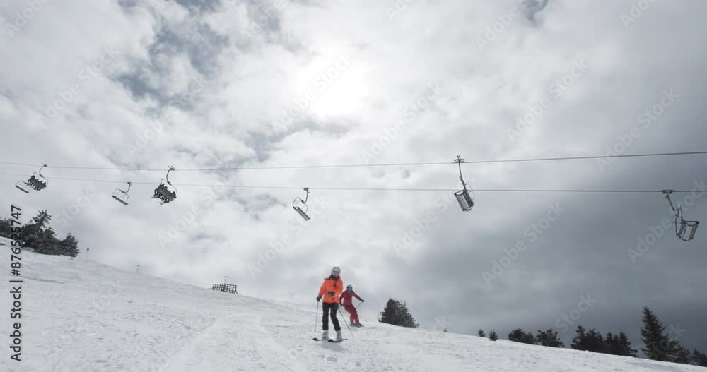 Girl and boy skiers skiing on slopes. Couple having fun together. Ski run 3 clip 2of2. Recorded on cinema camera 50fps. Girl and boy skiers skiing on slopes. Couple having fun together. Ski run 3 clip 2of2. Recorded on cinema camera 50fps.