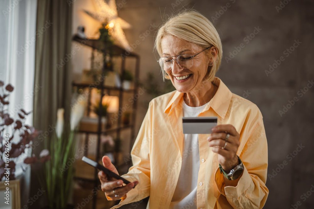 Fototapeta premium Mature senior woman buy online on mobile and use credit card