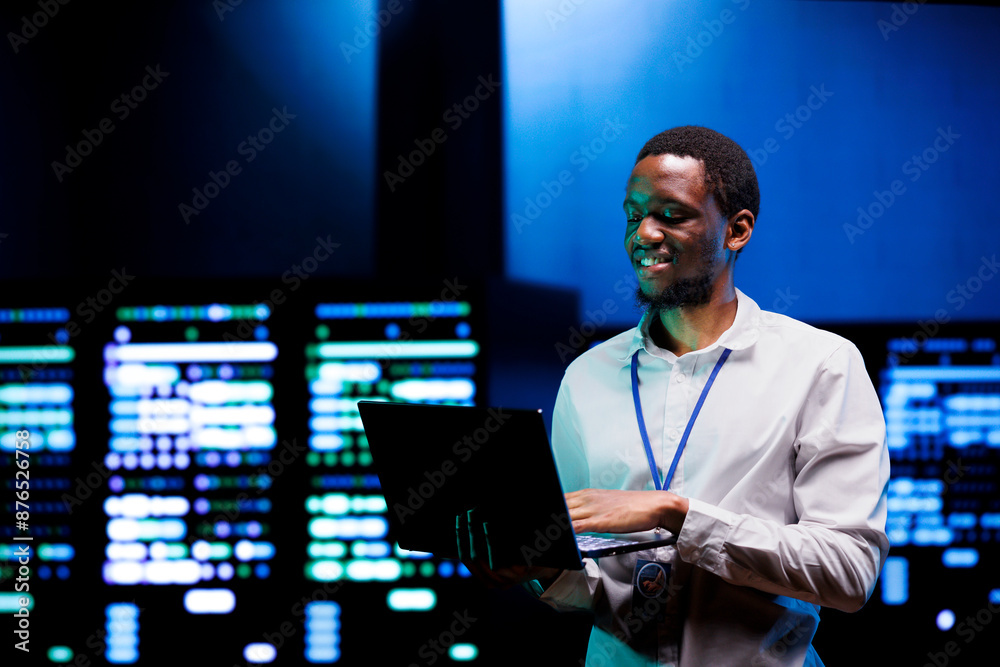 Cheerful technician doing checkup in server farm providing vast computing resources and storage. Data center enabling artificial intelligence to process massive datasets for training and inference