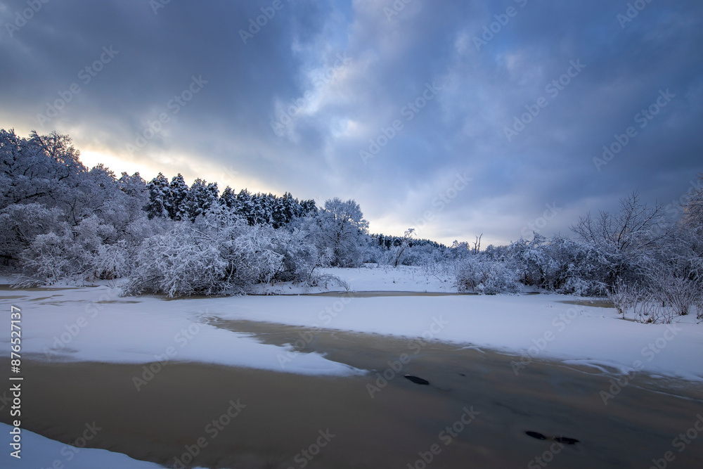 A snowy landscape with a lake and trees A snowy landscape with a lake and trees
