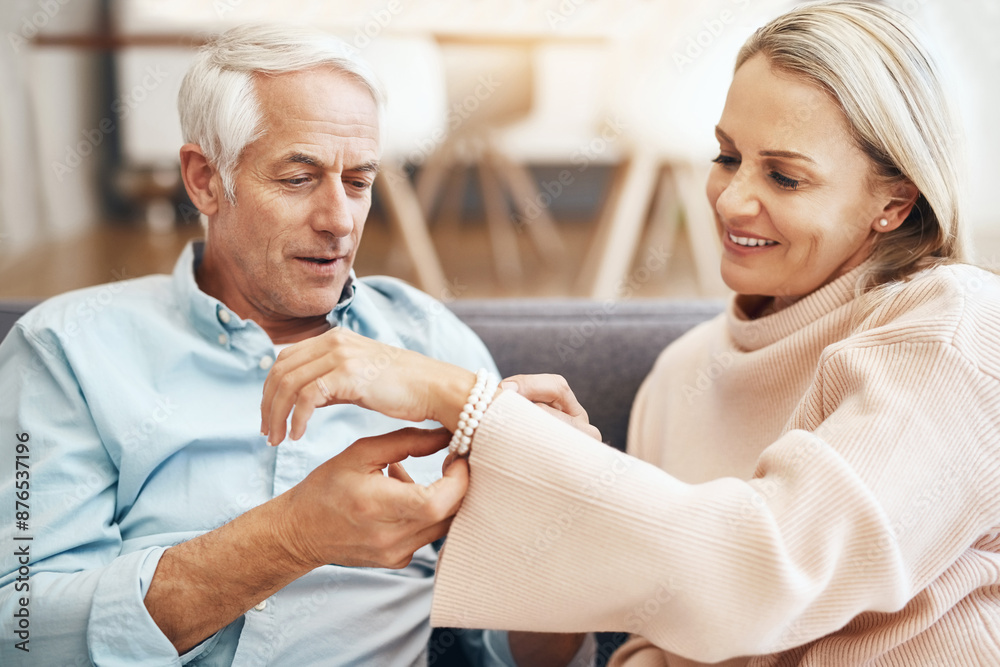 Obraz premium Mature couple, present and home with jewelry for anniversary, love and romantic gesture in living room. Happy woman, couch and man with bracelet for milestone, birthday gift and support in marriage