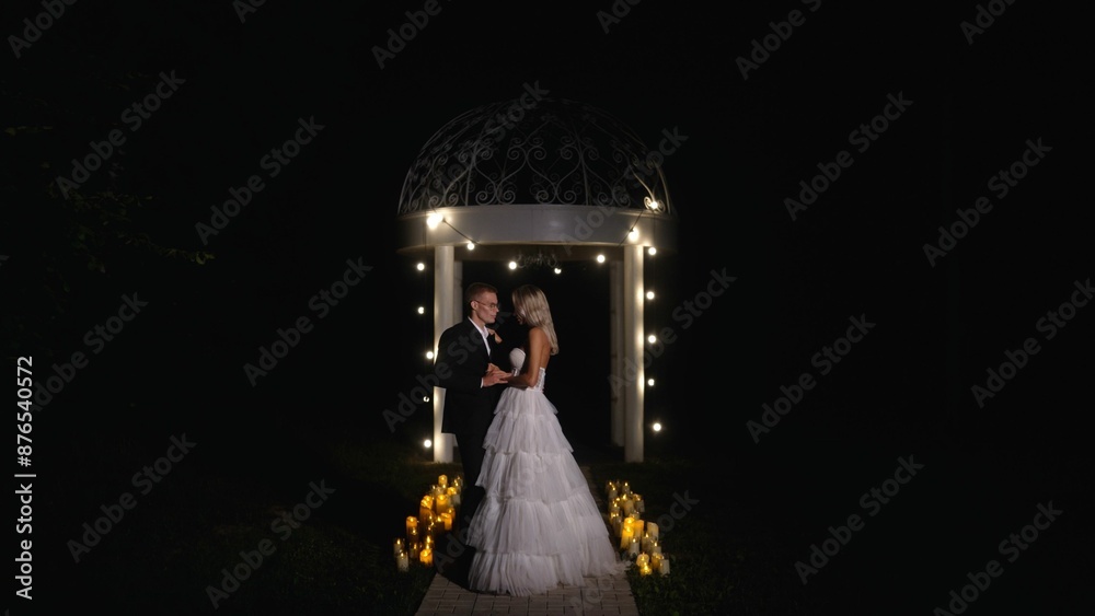 Tender and happy bride and groom on the evening street. Romantic walk and photo shoot in the dark. Night wedding ceremony. Young couple bride and groom on the street at night. Tender and happy bride and groom on the evening street. Romantic walk and photo shoot in the dark. Night wedding ceremony. Young couple bride and groom on the street at night.