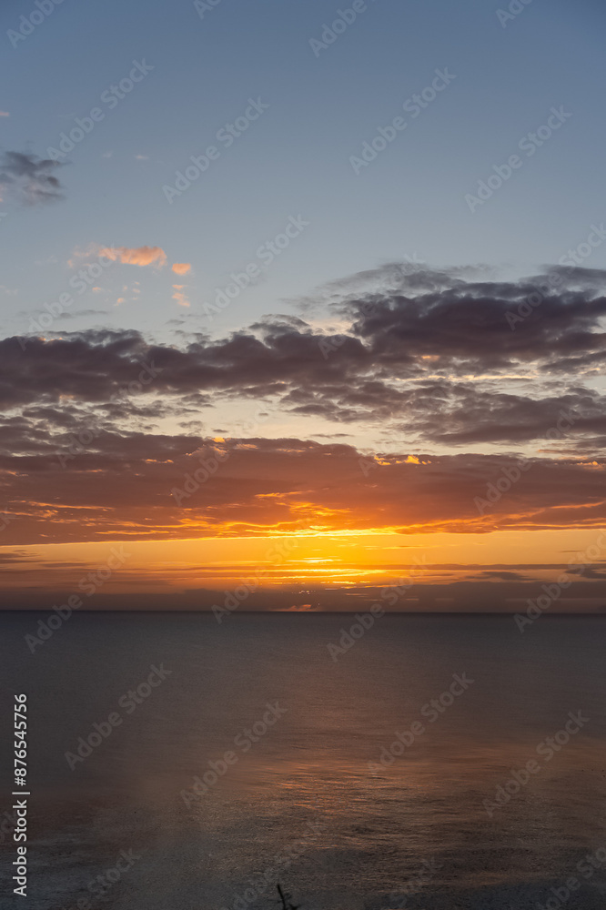 Fototapeta premium Bright colourful dawn in summer on the Baltic Sea. A couple of minutes before sunrise. Vertical photo High quality photo