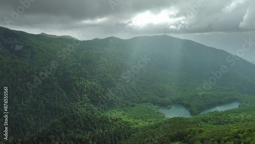 Aerial view of dark clouds and sun rays over summer green mountains landscape, Montenegro, 4k