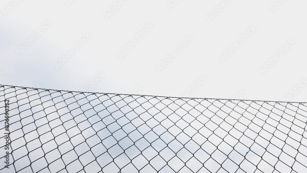 View through a wire mesh fence towards the sky View through a wire mesh fence towards the sky