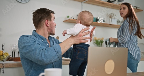 Playful Family Time: Dad Laughs as Baby Has a Little Accident at Home