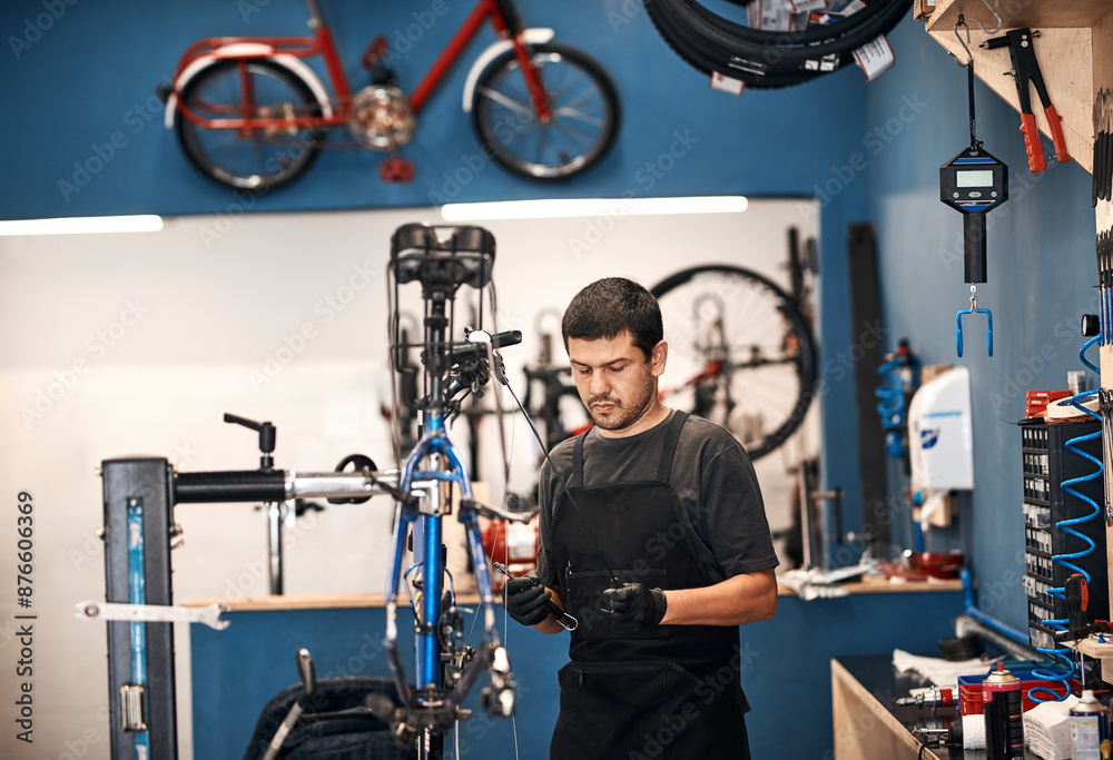 Obraz premium Bike repair, cable maintenance and man in workshop for frame building or professional engineering. Assessment, bicycle and transportation with mechanic or technician in startup for restoration