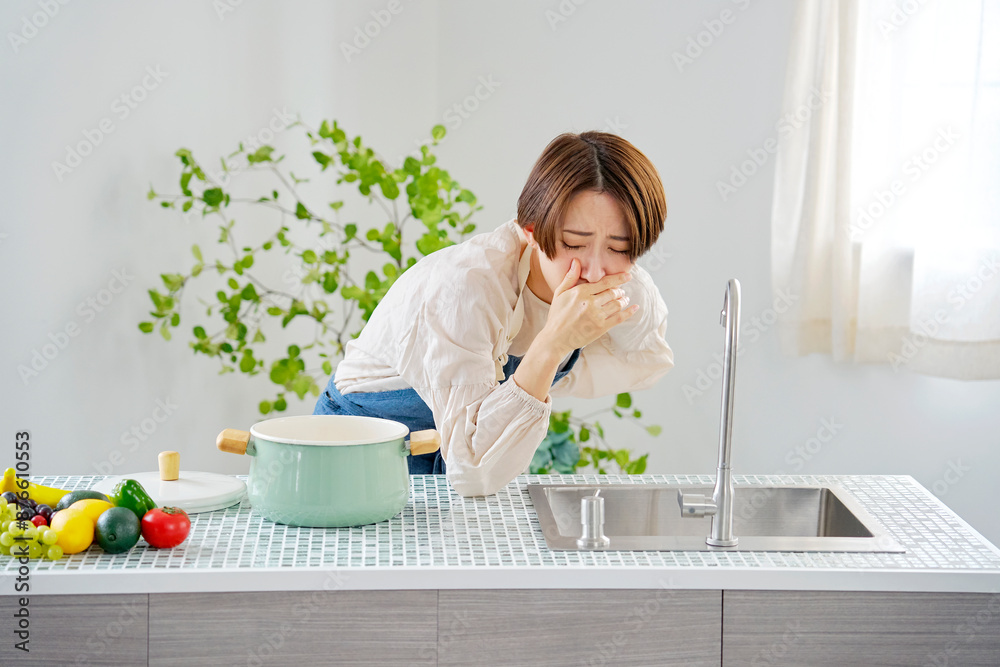 キッチンで吐き気がする女性 キッチンで吐き気がする女性