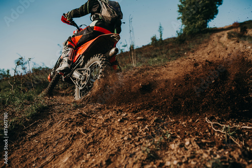 Professional enduro bike rider on action, dirt ride on the muddy road. Motocross sport.