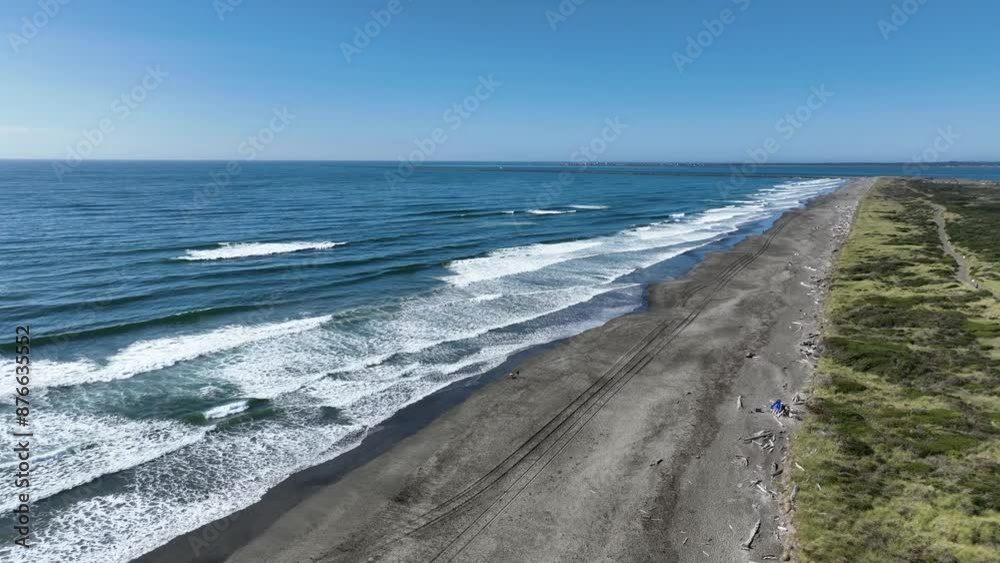 Aerial drone video of Washington State coast with waves rolling in to shore. Filmed in Westport, WA looking towards Grays Harbor.
