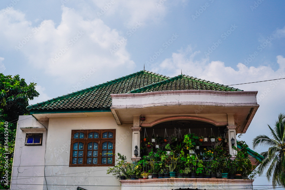 Two-story white-framed tropical house with empty photocopy space and potted plants on the second floor. Two-story white-framed tropical house with empty photocopy space and potted plants on the second floor.