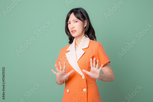 Foto Woman in an orange dress expressing disgust or disapproval, holding her hands up