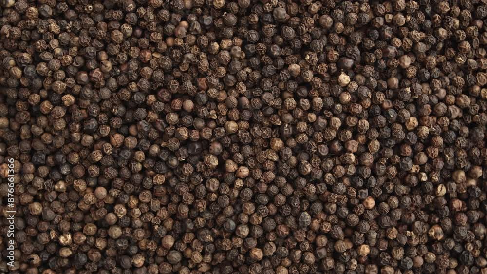 Close up on black pepper grains rotating, overhead view of many pepper grains filling the screen. Close up on black pepper grains rotating, overhead view of many pepper grains filling the screen.