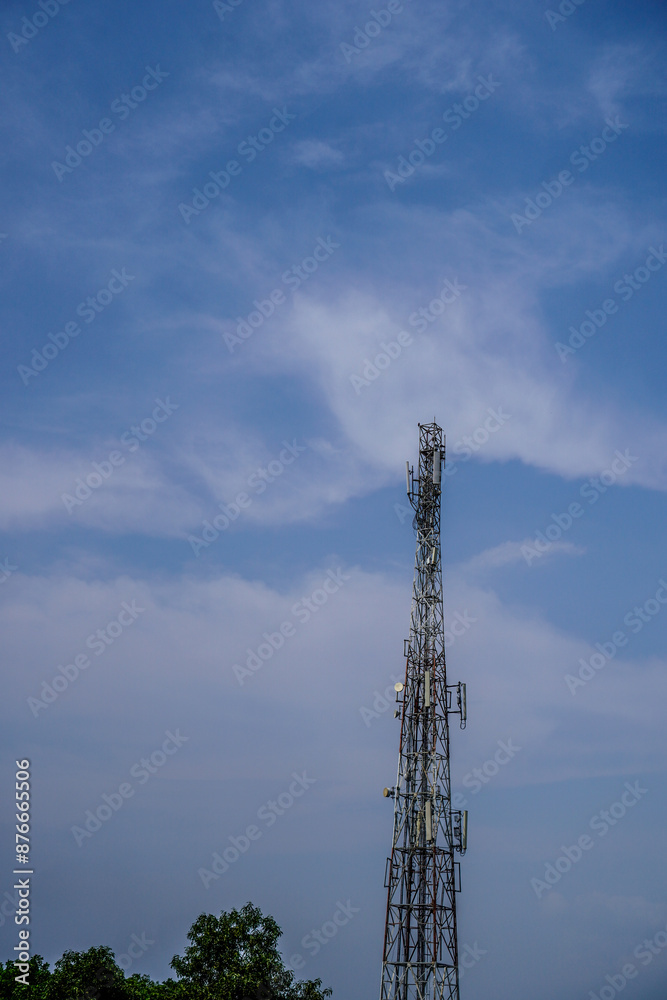 High communication antenna with floating clouds background behind it as advertising space.
