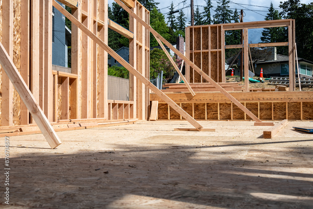 Wood framing started on new home construction job site, exterior walls with windows and subfloor
Wood framing started on new home construction job site, exterior walls with windows and subfloor