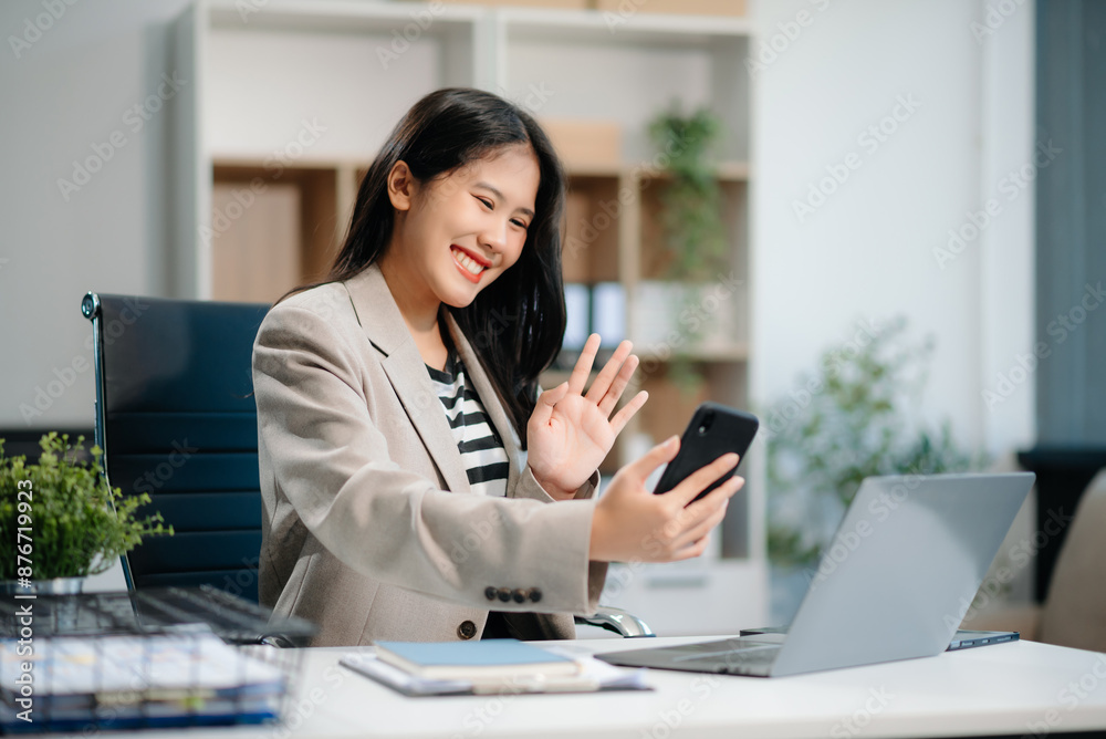 Beautiful Asian businesswoman typing laptop and tablet Placed at the table at the office Beautiful Asian businesswoman typing laptop and tablet Placed at the table at the office