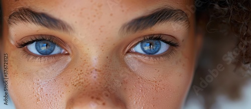 A detailed close-up of a person's blue eyes with freckles, showcasing an intense gaze and natural beauty.