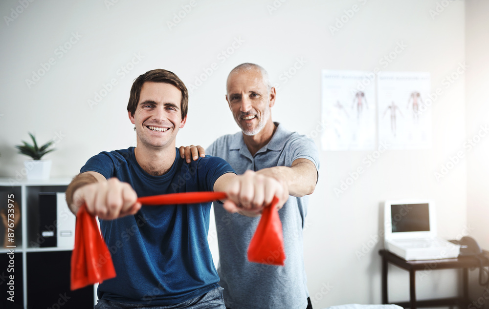 Portrait, resistance band training and man with physiotherapist in office for appointment or checkup. Exercise, fitness and smile of medicine professional with physiotherapy patient in rehab clinic
