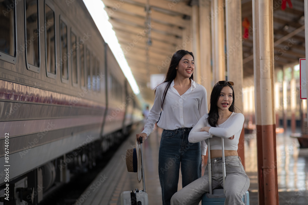 Two beautiful women walking along platform at train station, Two traveling women with suitcase backpacks walking around subway. Two beautiful women walking along platform at train station, Two traveling women with suitcase backpacks walking around subway.