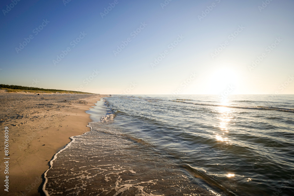Beautiful wide beach at sunset on the Baltic Sea. Clear, cloudless sky. Dunes and forest. Slajszewo, Choczewo, Poland.