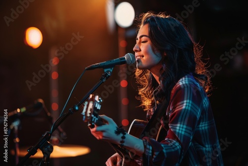 A young woman confidently sings into a microphone while holding a guitar on stage during an open mic night event © Ilia Nesolenyi