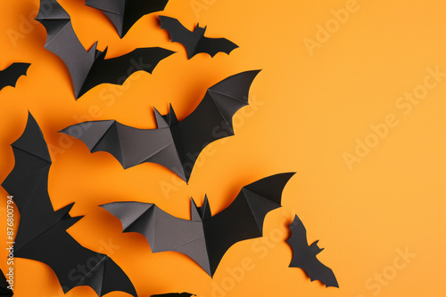 Halloween and decoration concept with paper bats flying isolated on orange background with copy space