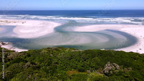 Drone tilt-up reveal scenic Klein River lagoon estuary river mouth breaching into ocean over famous Grotto Beach in Hermanus on the Overstrand photo