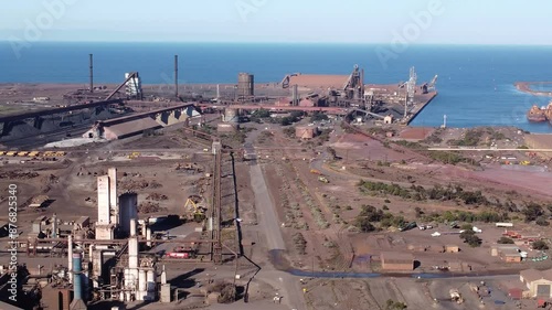 Drone shot of the GFG Alliance Whyalla Steelworks and harbor on the Spencer Gulf, South Australia. The large industrial factory employs local workers and processes iron ore. photo