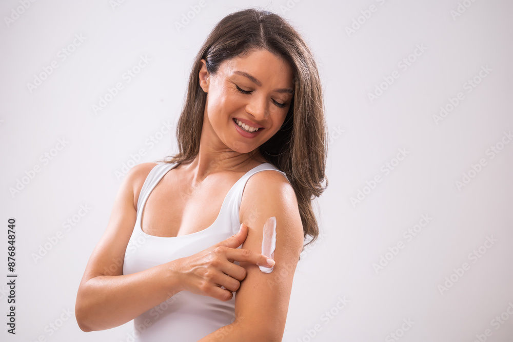 Portrait of adult woman who is applying skin cream on her skin. Portrait of adult woman who is applying skin cream on her skin.