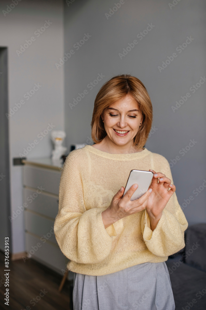 Smiling freelancer using mobile phone at home office Smiling freelancer using mobile phone at home office