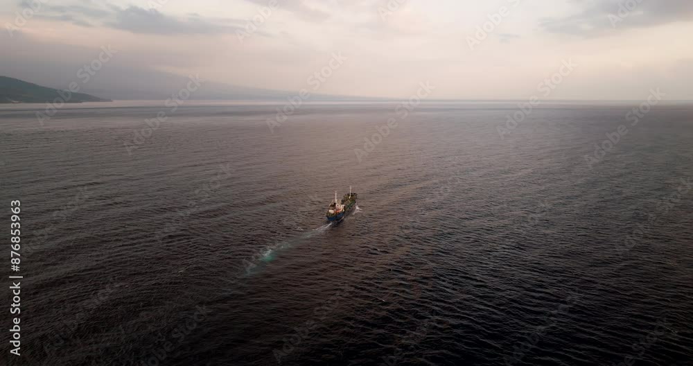 Big cargo ship navigating the open seas off Bali North Coast, aerial arc Big cargo ship navigating the open seas off Bali North Coast, aerial arc
