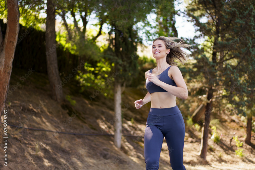 Happy woman in sports clothes running on sports track Happy woman in sports clothes running on sports track