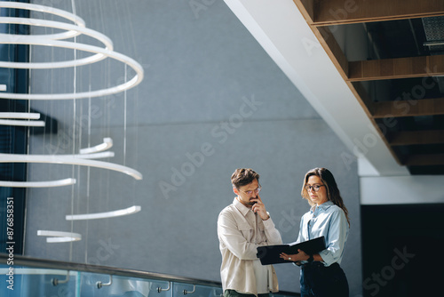 Business people read and discuss the terms of their agreement in an office setting