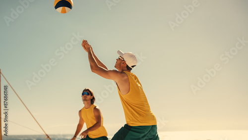 Professional australian volleyball team soaring in mid-air at coastal beach tournament photo