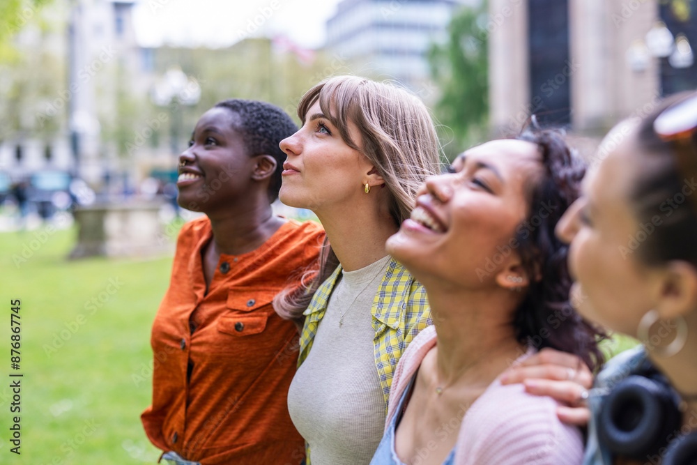 Multiracial female friends walking side by side at park Multiracial female friends walking side by side at park