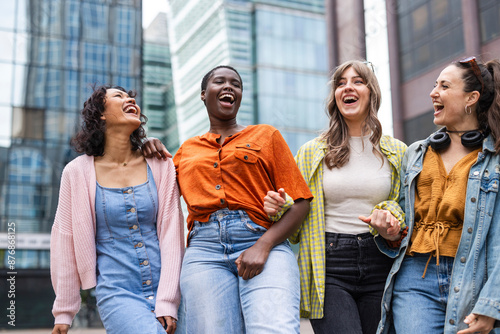 Happy female friends standing in city photo