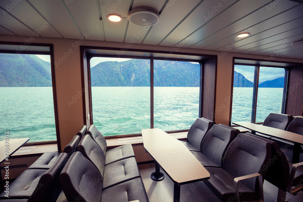 Fototapeta premium Sea cruise on a ship. View of the fjord from the boat. View through the ship window of the sea and mountain coast. Norway